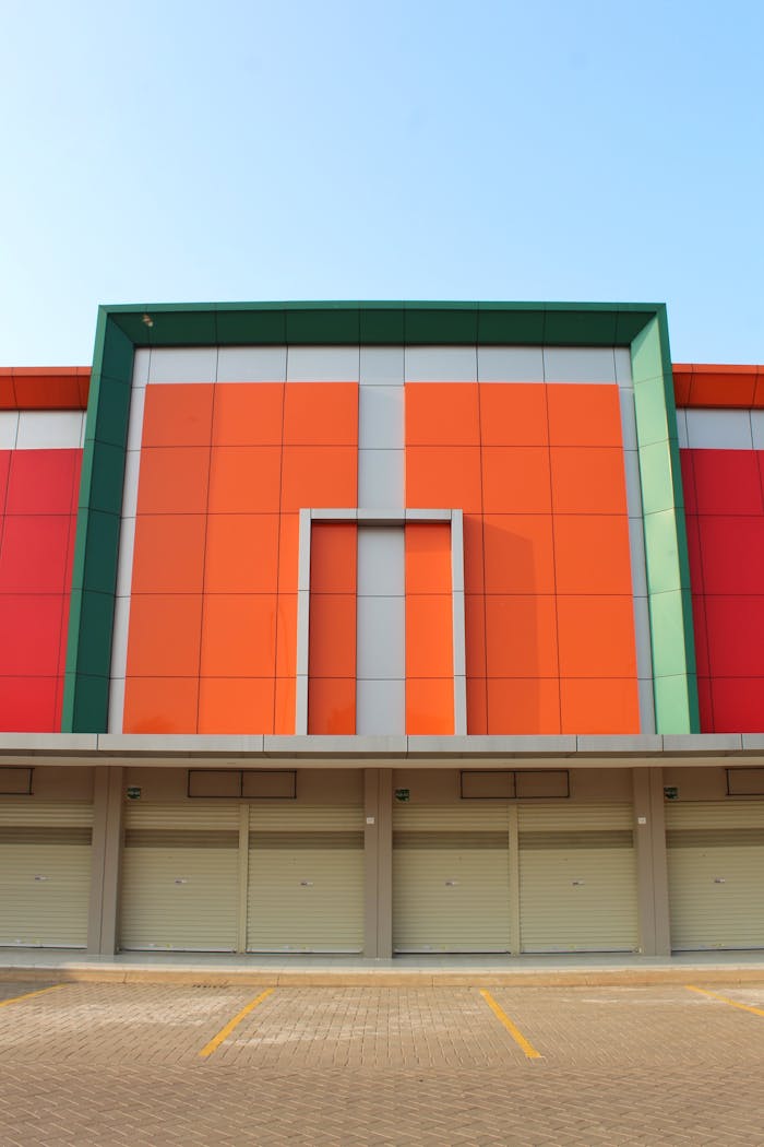 our-services-2 Symmetrical front view of a vibrant building exterior with closed garage doors and colorful panels.
