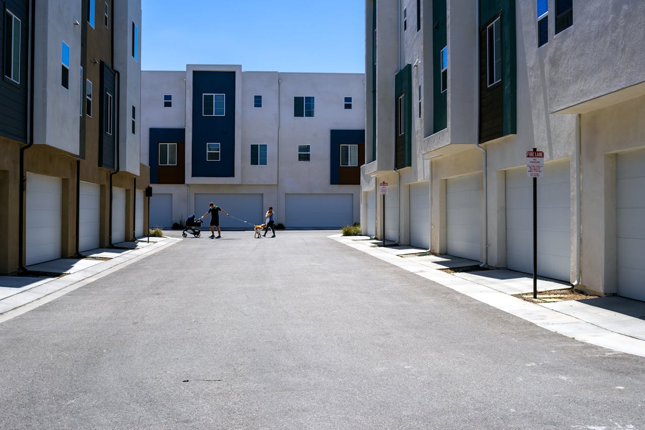 gallery-3 A quiet urban alley framed by sleek modern residential buildings under a summer sky.