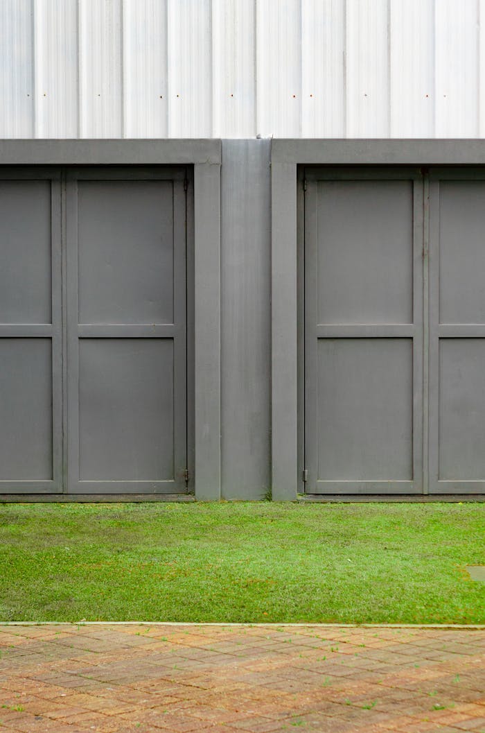 our-services-3 Close-up of two modern gray garage doors with grass and pavement.